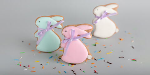 Tasty Easter cookies in shape on bunny and sprinkles on grey background