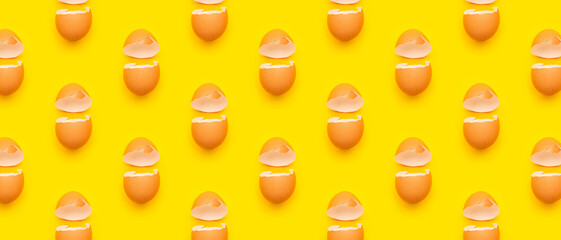 Cracked egg shell on yellow background