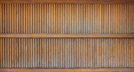 Wooden doors made of slats are old and uneven in color. It is a detailed panorama.