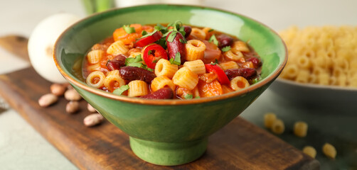 Bowl with tasty pasta and beans on table, closeup