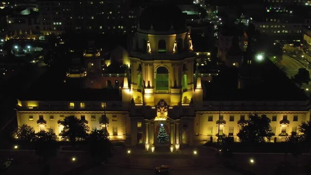 Pasadena City Hall at night with Christmas tree, aerial pull back over city lights, establishing cinematic view