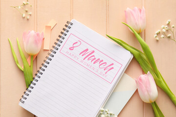 Notebook with text 8 MARCH, HAPPY WOMEN'S DAY and beautiful flowers on color background