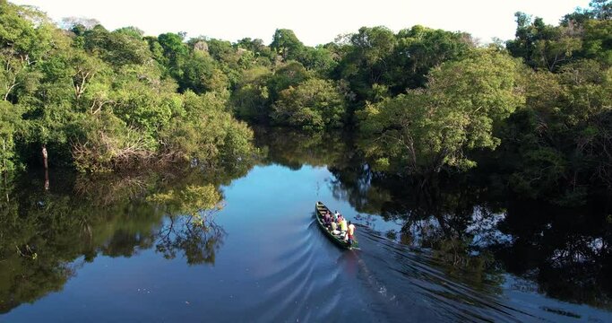 barco no rio da floresta amazonica no por do sol
