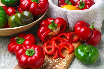 Different fresh bell peppers on fabric background, closeup