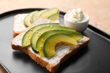 Plate of tasty sandwiches with cream cheese and avocado on color background, closeup