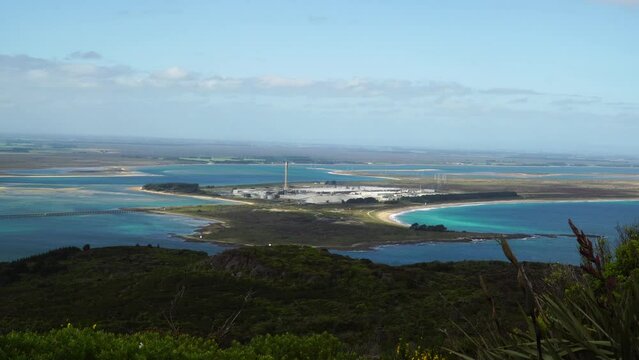 Zoom in to Tiwai Point Aluminium Smelter as seen from the top of Bluff Hill in New Zealand 