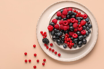 Plate with fresh berries on color background