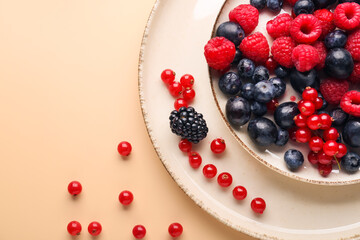 Plate with fresh berries on color background, closeup