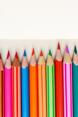 Set of colorful pencils on notebook, closeup