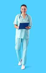 Female medical assistant with clipboard on light blue background