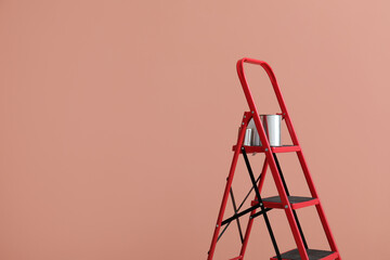 Maintenance ladder with cans of paint near color wall