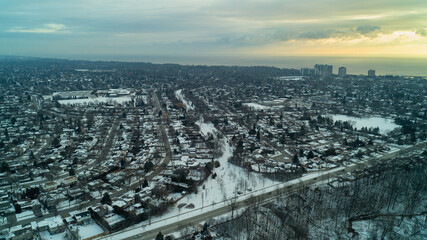 The sun rises over Lake Ontario with a Forest, River and suburbs in the foreground