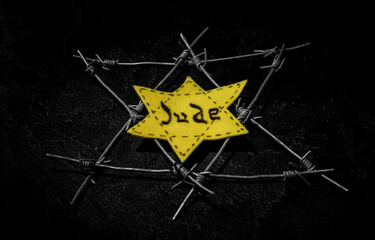 Jewish badge and barbed wire on dark background. International Holocaust Remembrance Day