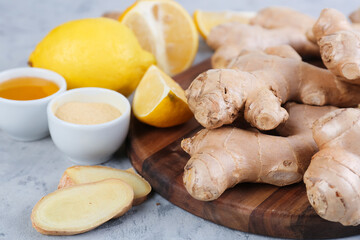 Cutting board with fresh ginger, honey and powder on grunge table, closeup