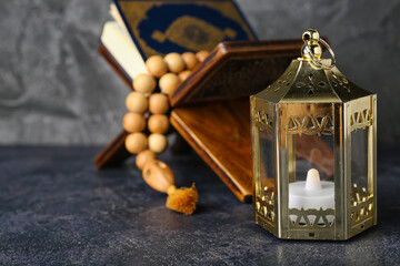 Lantern with Koran and prayer beads on dark background, closeup. Islamic New Year celebration