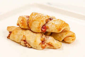 Rugelach cookies are made on cream cheese dough with strawberry jam, and mixed nuts topped with cinnamon sugar. 