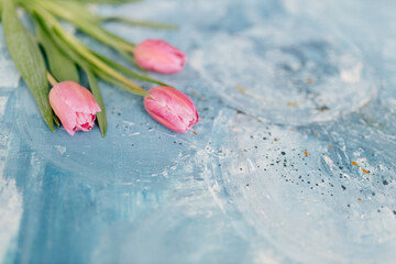 A bouquet of pink fresh tulips lies on a blue and turquoise scenic art background. Abstract blue art background. Fragment of artwork. Contemporary art. Oil paint Valentine's Day Background 