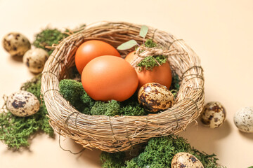 Nest with Easter eggs and moss on beige background