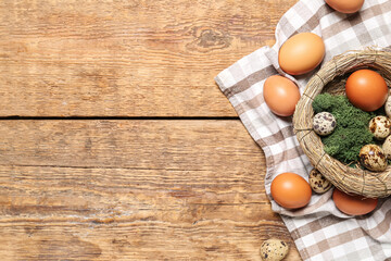Nest with Easter eggs and moss on wooden background