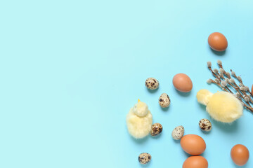 Easter eggs, pussy willow branches and baby chickens on blue background