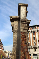 Ruins in Milan. A cross-section of walls from different eras, back-to-back. Blue sky background.