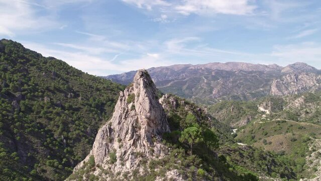 Aerial view in orbit of a high mountain peak and parallax effect with mountains and Mediterranean forest in the background. Grenade. Spain.