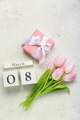 Beautiful tulip flowers, cube calendar and gift for Women's Day celebration on light background