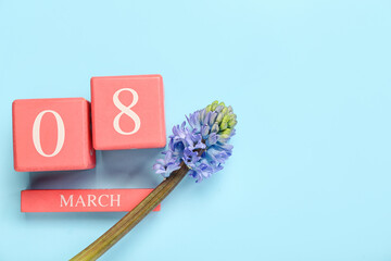Beautiful hyacinth flower and cube calendar with date of MARCH 8 on color background