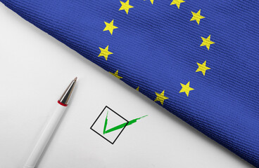 pencil, flag of European Union and check mark on paper sheet
