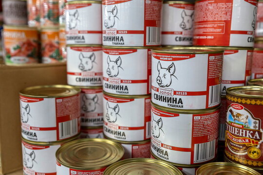 Russia Samara June 2022: A selection of canned stews in a shop. Text in Russian: stewed pork, meat reserve, premium, GOST