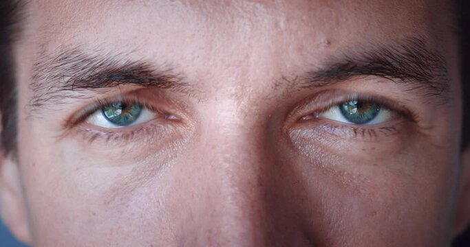 Close up of Man's face. Caucasian young man with blue eyes looking at camera. Vision of millennial man 30, slow-motion, macro extreme close-up.