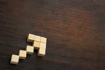 左の手前から奥を指している矢印の形に並べたウッドキューブの角度が付いた背景