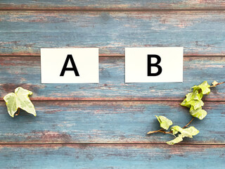 AとBの文字入り2枚の白いカード_青板背景