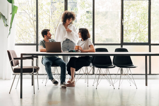 Group of young colleagues interacting in spacious bright loft coworking space. Creative ideas. Startup.