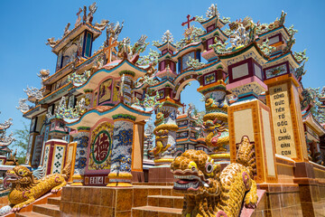 Fototapeta premium An ornate memorial monument covered in colourful mosaics and dragon figures at a cemetery in Vietnam