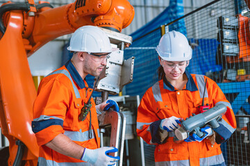 engineer team worker working program robot arm assembly machine in modern metal heavy industry factory