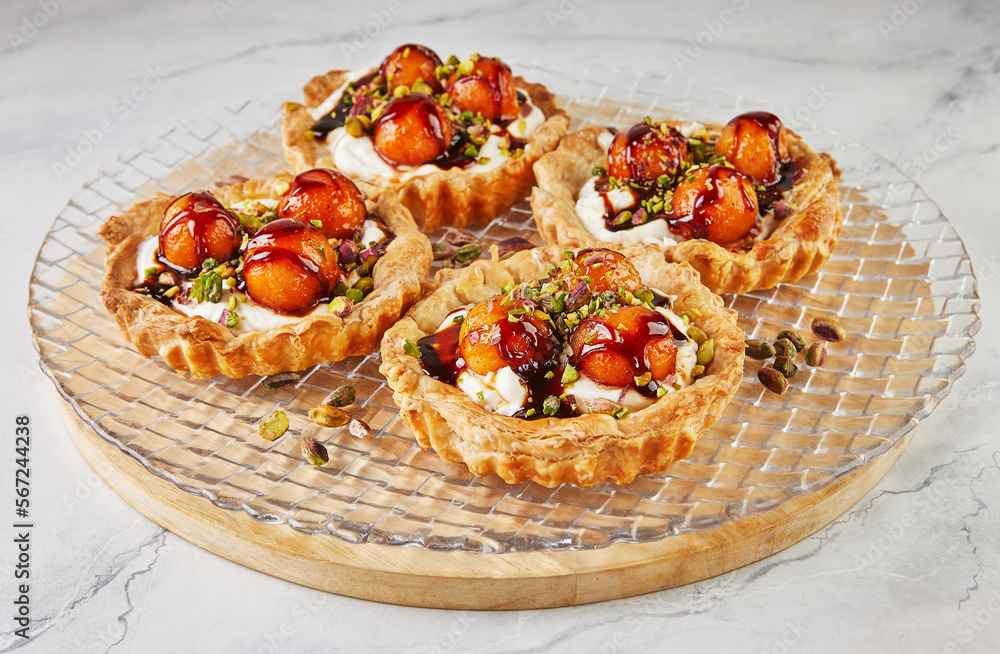 Sticker Tartlets with melon, mascarpone and pistachios on transparent plate