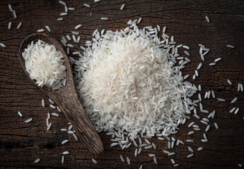 Rice with wooden spoon on wood texture