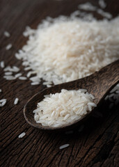 Rice with wooden spoon on wood texture