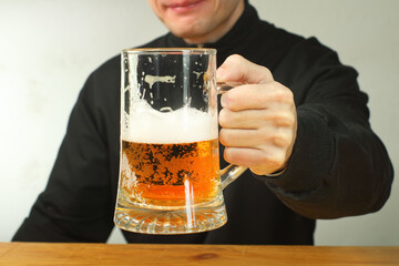 person holding a mug of beer