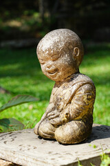Fototapeta na wymiar Child monk happy smiling laughing face doll Buddha, old stone art statue decoration in outdoor green scenery at Wat Pha Lat, Doi Suthep, Chiangmai temple, Thailand 