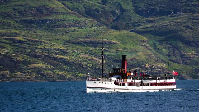 TSS Earnslaw vessel sailing near New Zealand landscape, follow view