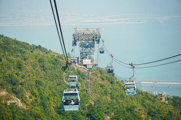 Operating trams with tower over hillside in Asia