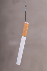 cigarettes on fish hooks. wooden background in retro style. dependence on cigarettes.