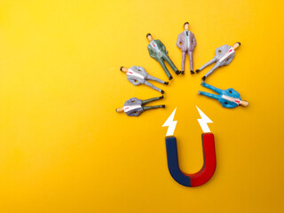 Businessman attracts by magnet on a yellow background. Business and leadership concept.