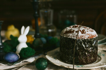 table set for Easter on veranda on sunny spring day decorated with flowers and Easter decor, eggs, cake and willow branches, Easter family celebration, grain and noisy effect