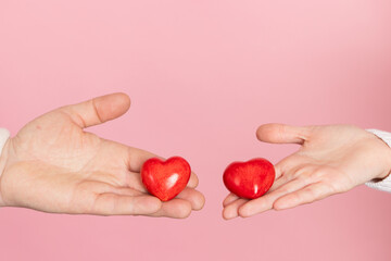 closeup hands holding heart on pink background, valentine's day concept