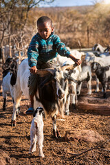 African child riding a goat
