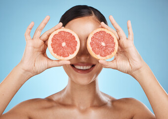 Skin care, grapefruit and beauty woman fruit face for dermatology, cosmetics and wellness. Aesthetic model for natural sustainable facial glow, nutrition diet and healthy smile on blue background
