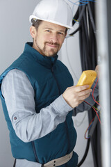 an electrician measuring voltage of cables